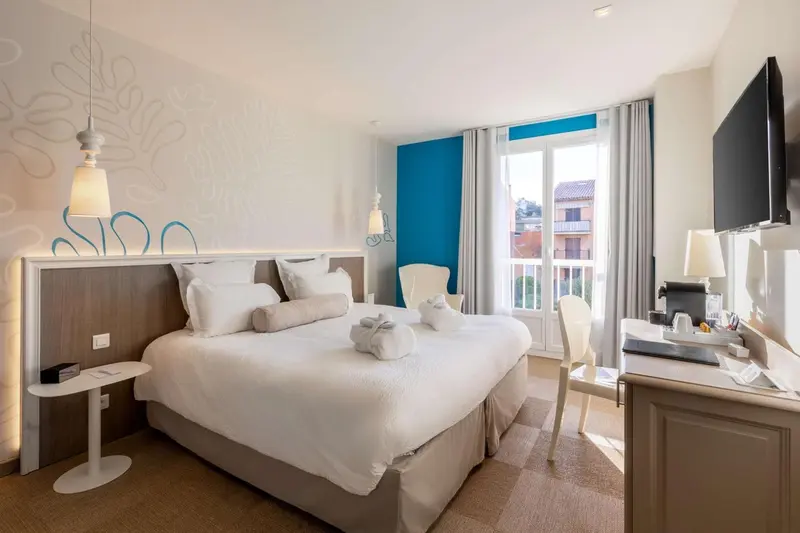 Une chambre lumineuse avec un grand lit et un bureau.