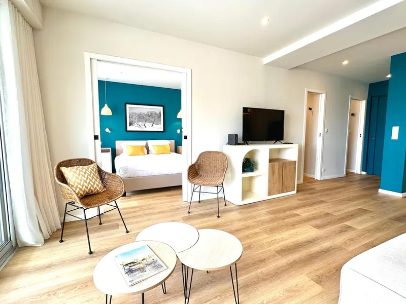 Une chambre lumineuse avec un lit et un espace salon.