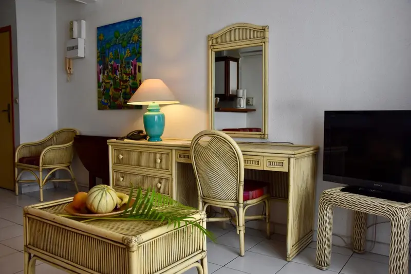 Une pièce lumineuse avec un bureau en rotin et des fruits frais.