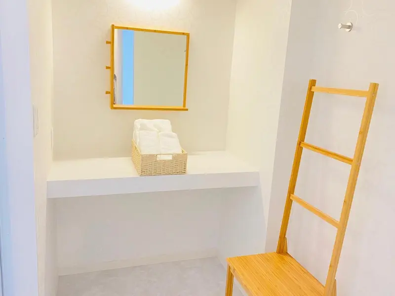 Une salle de bain minimaliste avec un miroir et des serviettes pliées.
