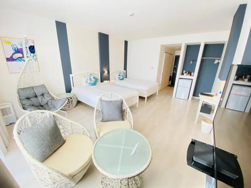 Chambre lumineuse avec coin salon et décoration marine.