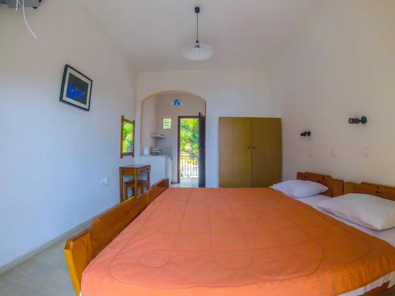 Une chambre lumineuse avec un lit et un accès à un espace extérieur.