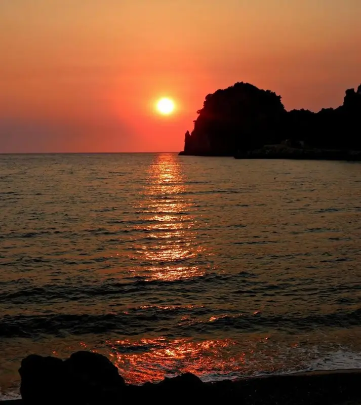 Le soleil se couche sur la mer, illuminant l'horizon de couleurs chaudes.