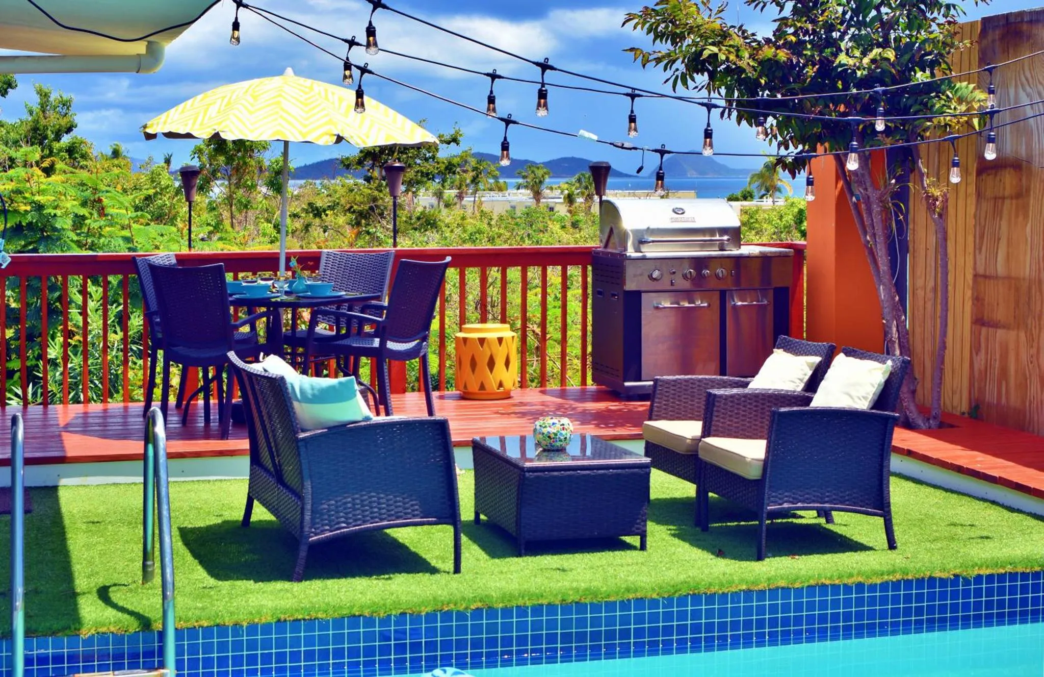 Terrasse aménagée avec salon et coin repas près d'une piscine.