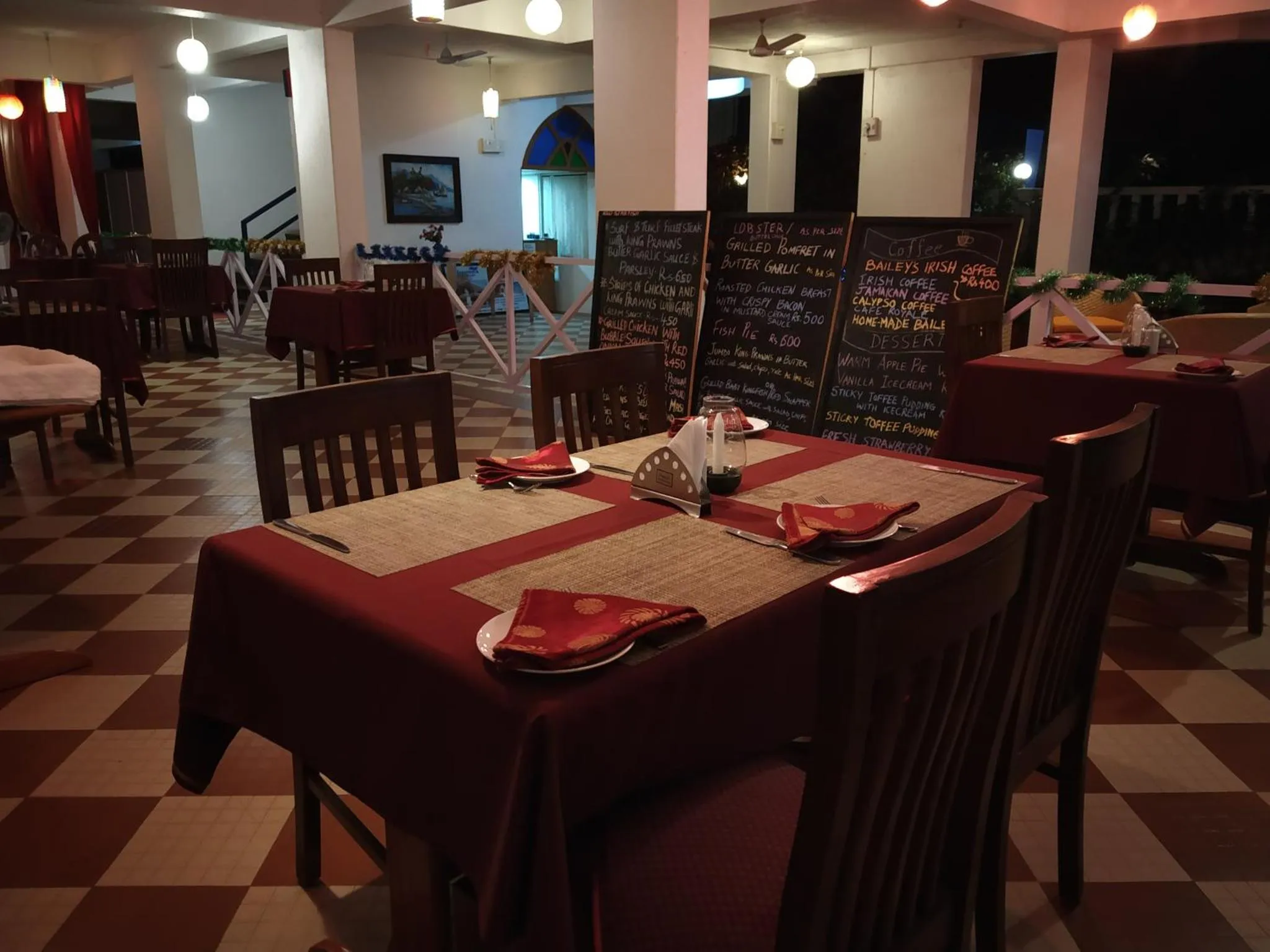Une table dressée dans une salle à manger avec des menus au tableau.