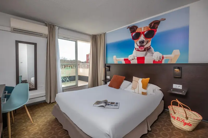 Chambre avec un grand lit et une décoration murale colorée.