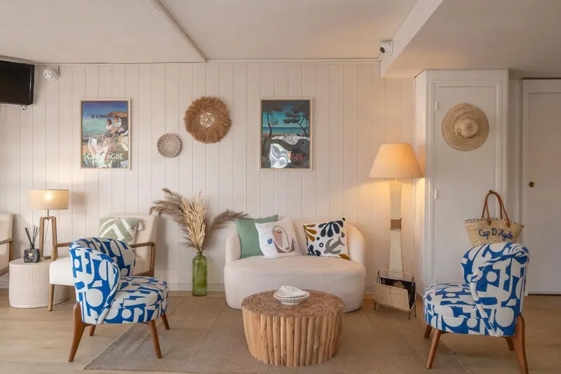 Un salon clair avec des fauteuils et un canapé.