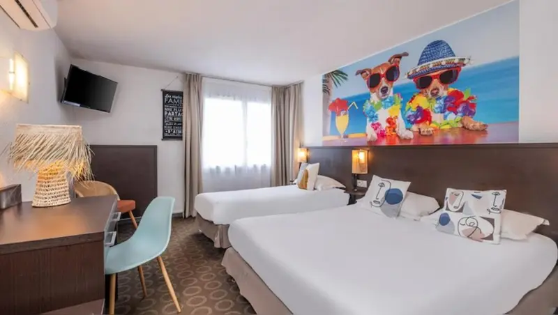 Une chambre d'hôtel lumineuse avec deux lits simples et une décoration colorée.
