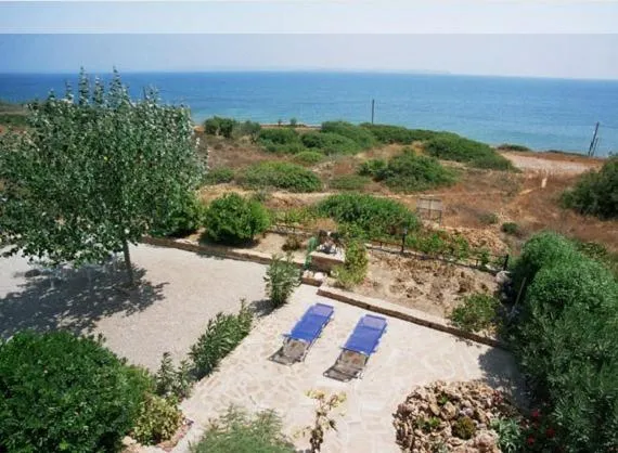 Transats bleus sur une terrasse ensoleillée avec vue sur la mer.
