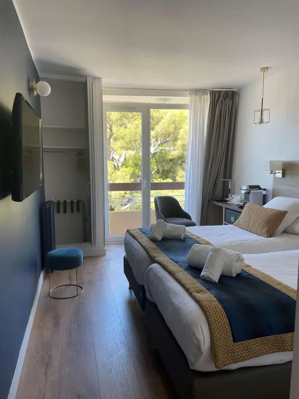 Une chambre lumineuse avec un lit double et un accès à un balcon.