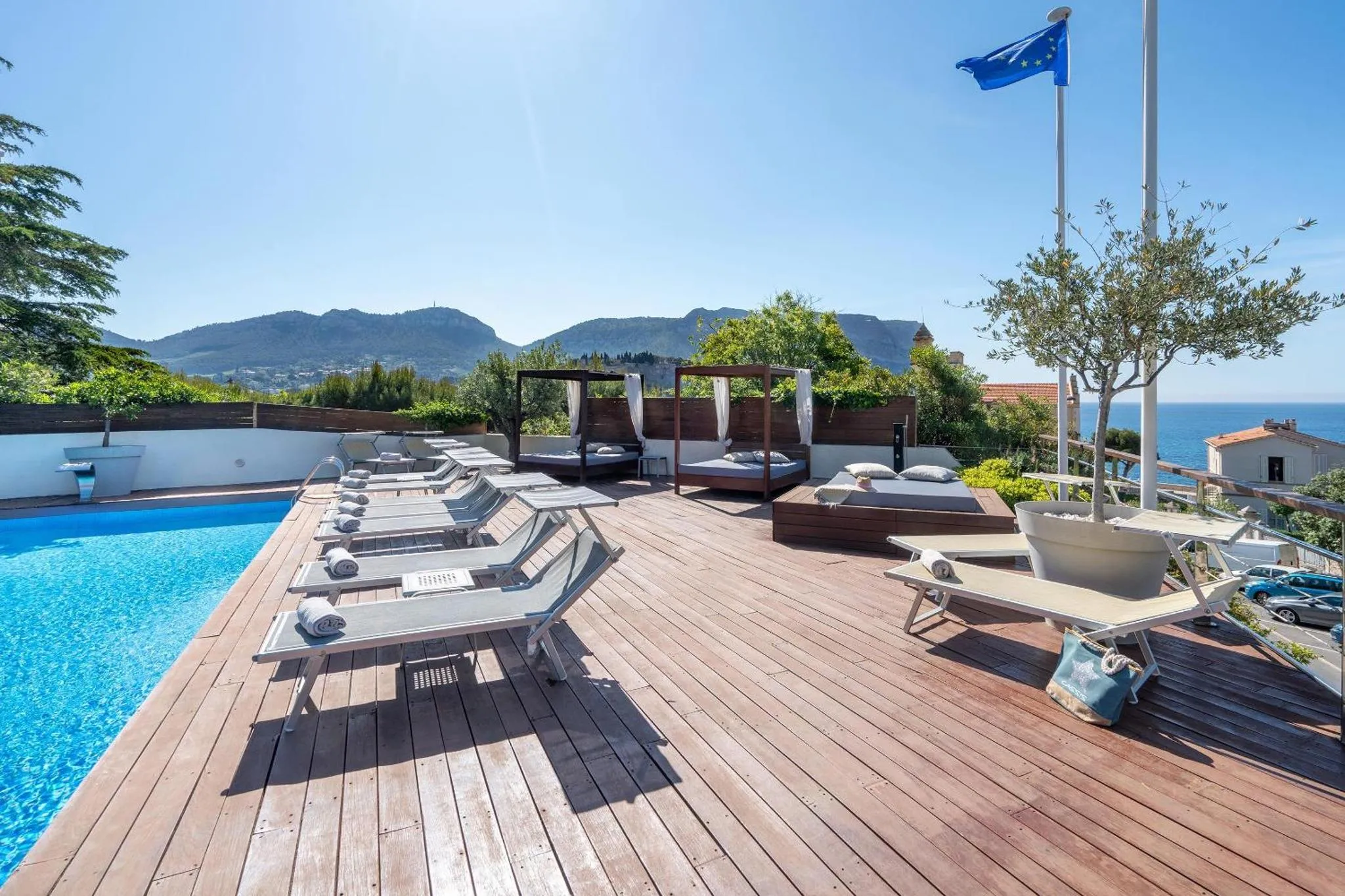 Terrasse avec transats et piscine face à la mer.