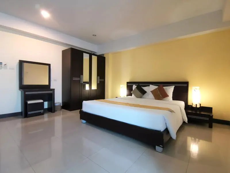 Une chambre lumineuse avec un grand lit et un meuble de rangement.