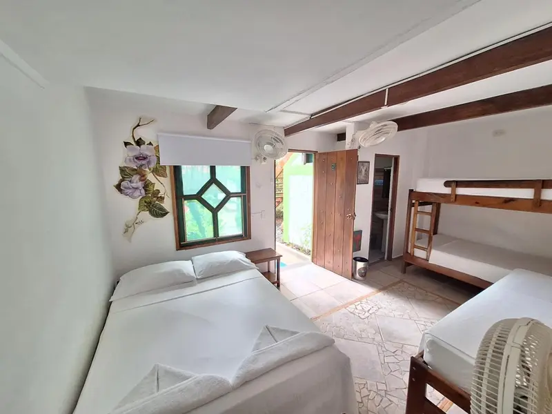 Une chambre lumineuse avec lits simples et lits superposés.