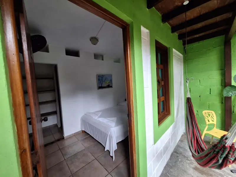 Une chambre lumineuse avec un lit simple et un escalier menant à un niveau supérieur.