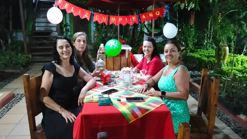Quatre personnes sont assises autour d'une table décorée en extérieur.