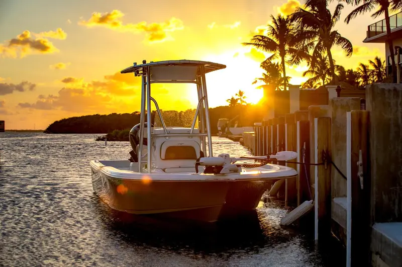 Un bateau amarré au bord de l'eau au coucher du soleil.