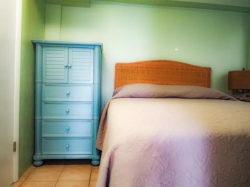 Une chambre avec un lit et une commode bleue.