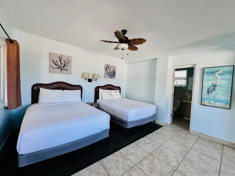 Une chambre lumineuse avec deux lits simples et une décoration marine.