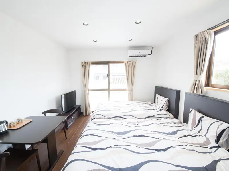 Une chambre lumineuse avec un lit double et un coin repas.