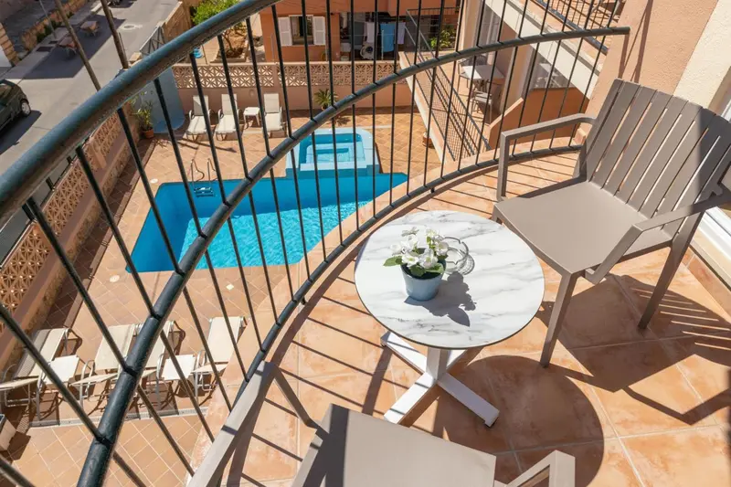 Terrasse avec table et chaises donnant sur une piscine.