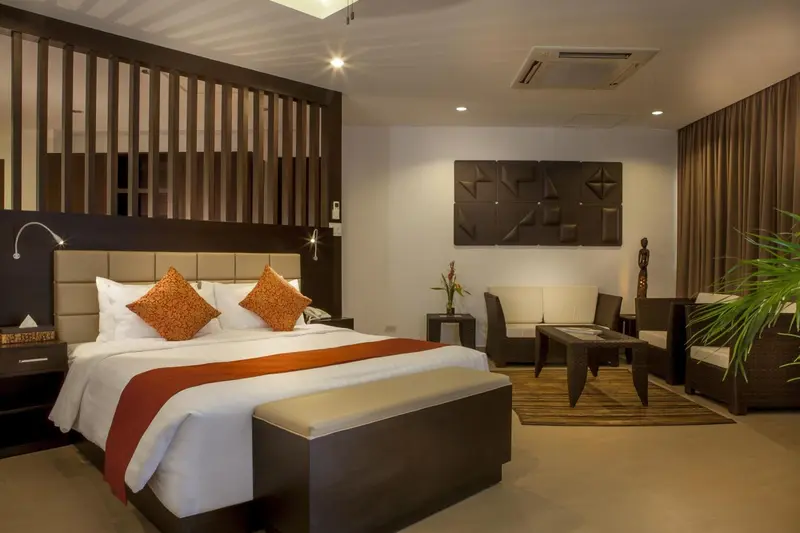 Une chambre d'hotel avec un grand lit et un espace salon.