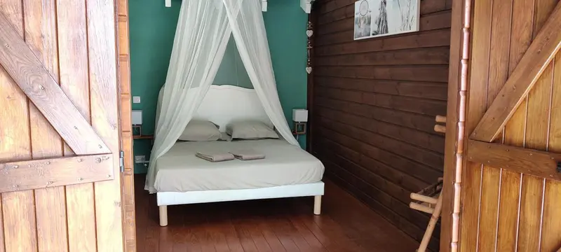 Une chambre lumineuse avec un lit à baldaquin et un décor en bois.