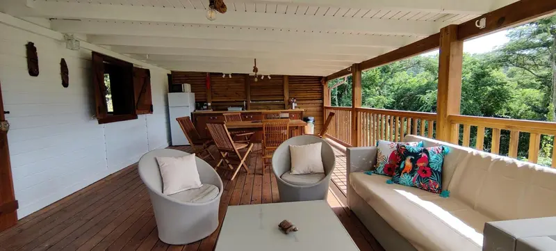 Espace de vie extérieur avec salon et coin repas.