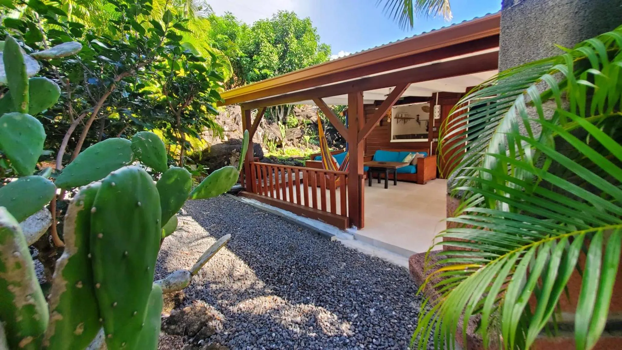Terrasse ombragée donnant sur un espace de détente extérieur.