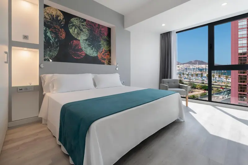 Chambre moderne avec un grand lit et une vue sur la mer.