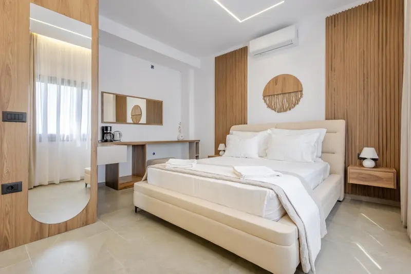 Chambre lumineuse avec un grand lit et un bureau en bois.
