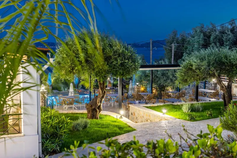 Terrasse lumineuse avec tables et chaises au milieu d'une végétation luxuriante.