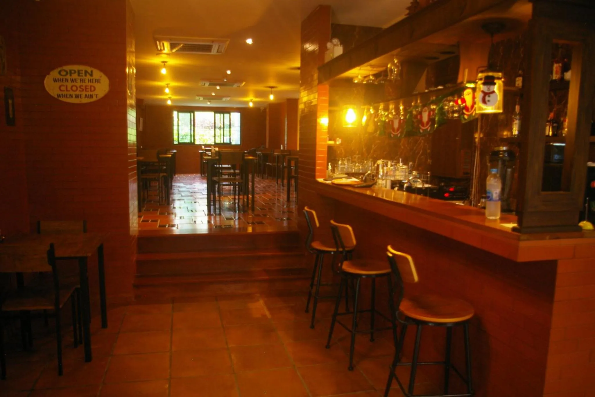 Un bar chaleureux avec un comptoir en bois et des tabourets.