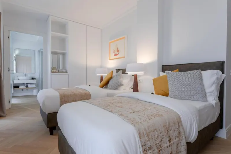 Une chambre lumineuse avec deux lits simples et une décoration sobre.