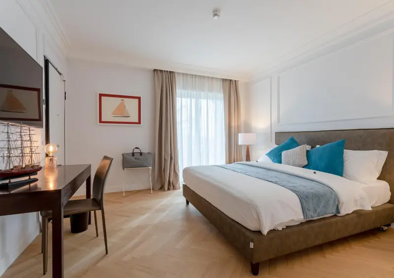 Une chambre lumineuse avec un grand lit et un bureau.