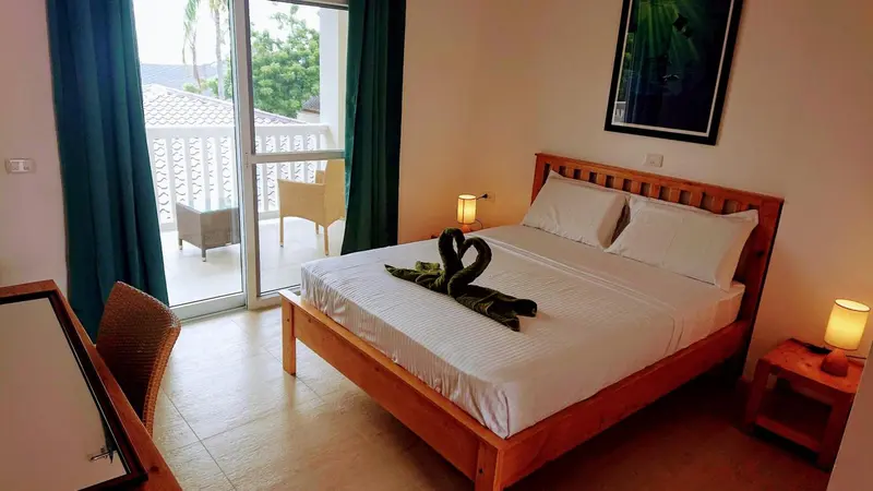 Une chambre lumineuse avec un grand lit et un accès à une terrasse.