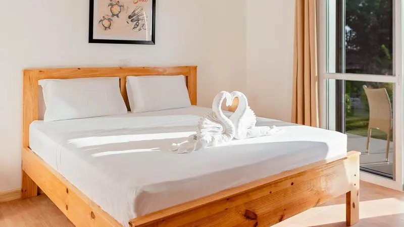 Lit double préparé avec soin dans une chambre lumineuse.