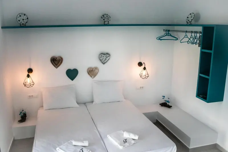 Une chambre lumineuse avec un lit double et des décorations murales.