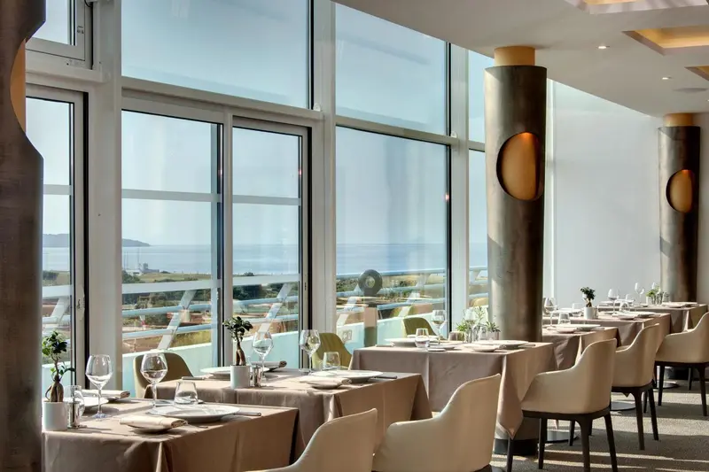 Une salle à manger lumineuse offre une vue sur la mer.