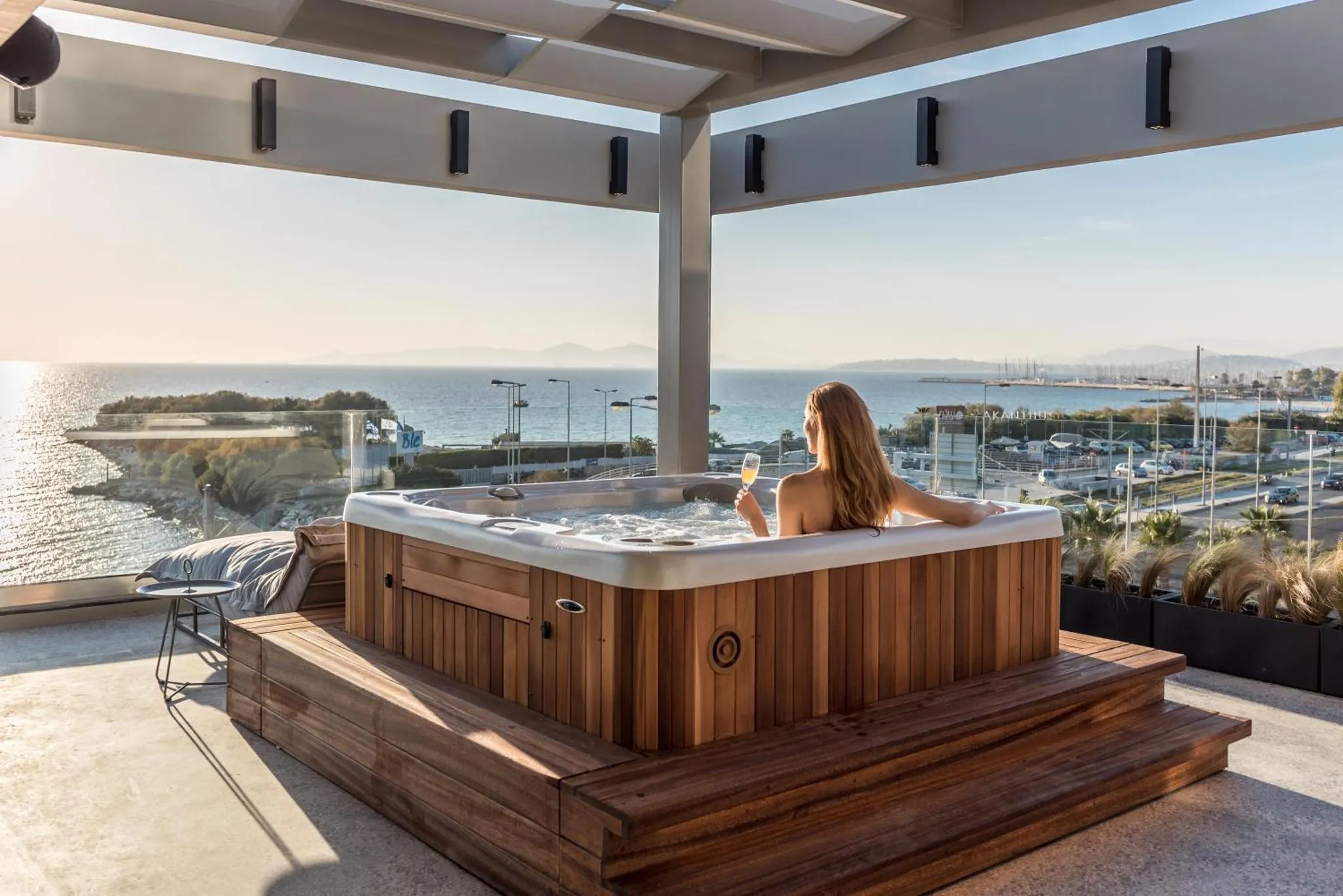 Une personne se détend dans un jacuzzi extérieur avec vue sur la mer.