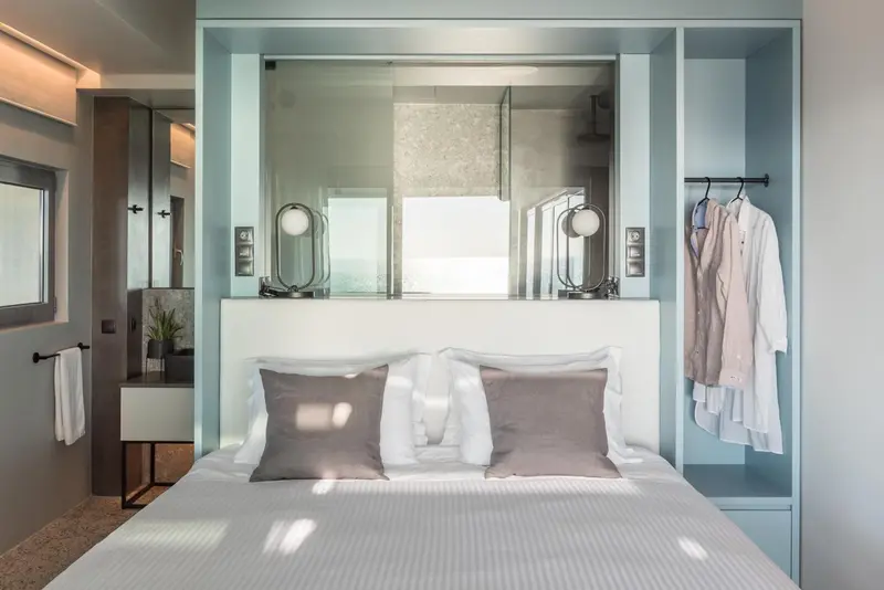 Une chambre lumineuse avec un grand lit et une salle de bain ouverte.