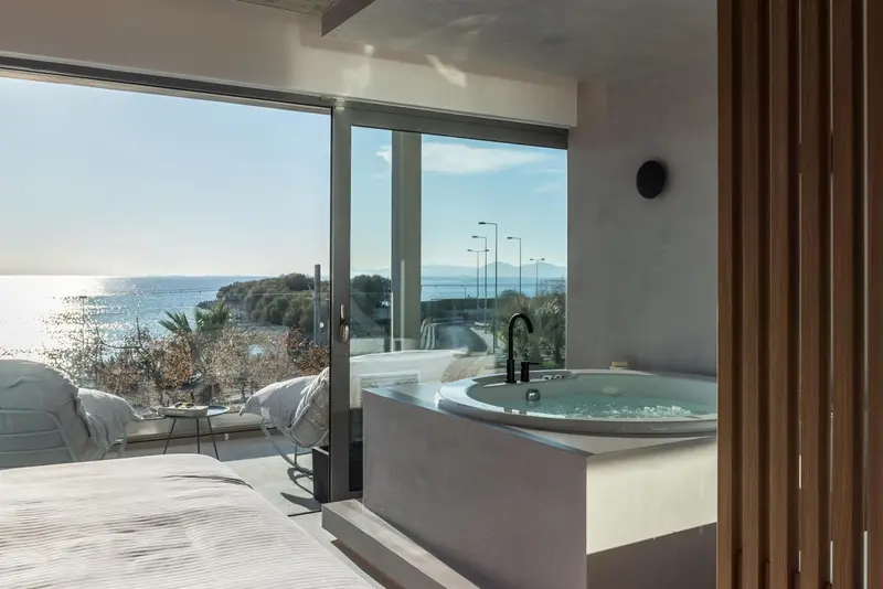 Une chambre lumineuse avec un bain à remous face à la mer.