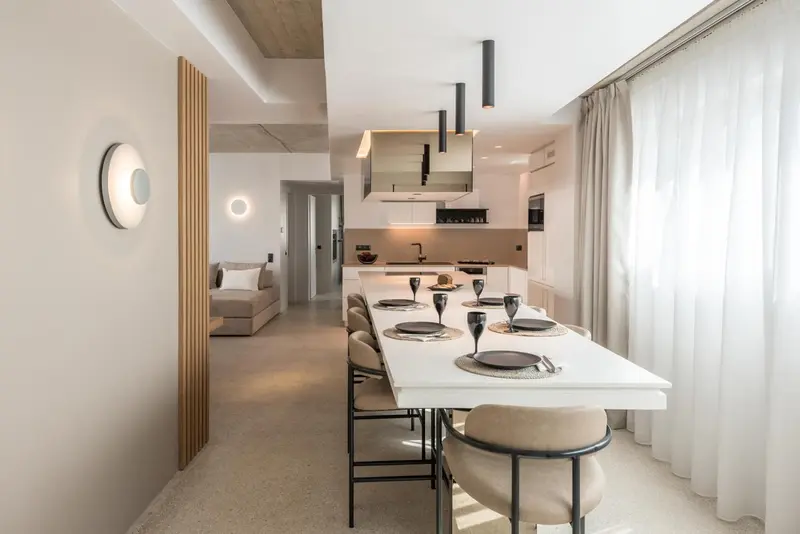 Une table à manger est mise en scène dans un espace intérieur lumineux.
