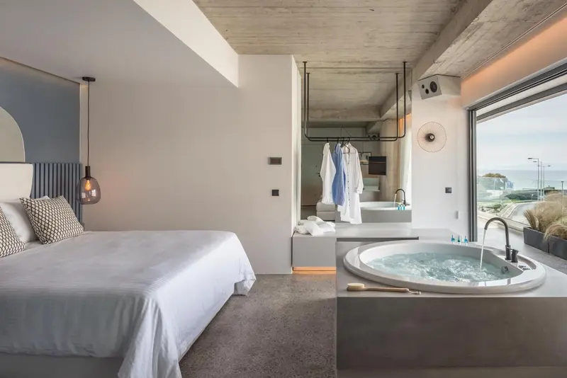 Une chambre lumineuse avec un grand lit et une baignoire à remous.