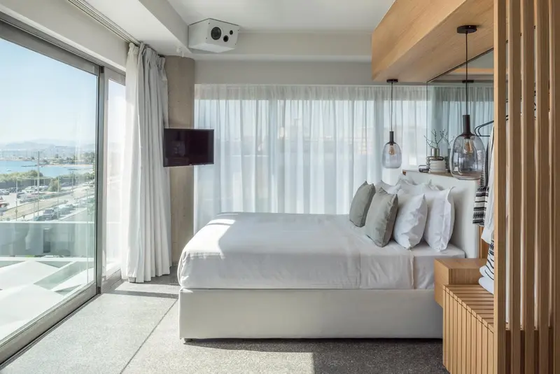 Une chambre lumineuse avec un grand lit et une vue sur la mer.