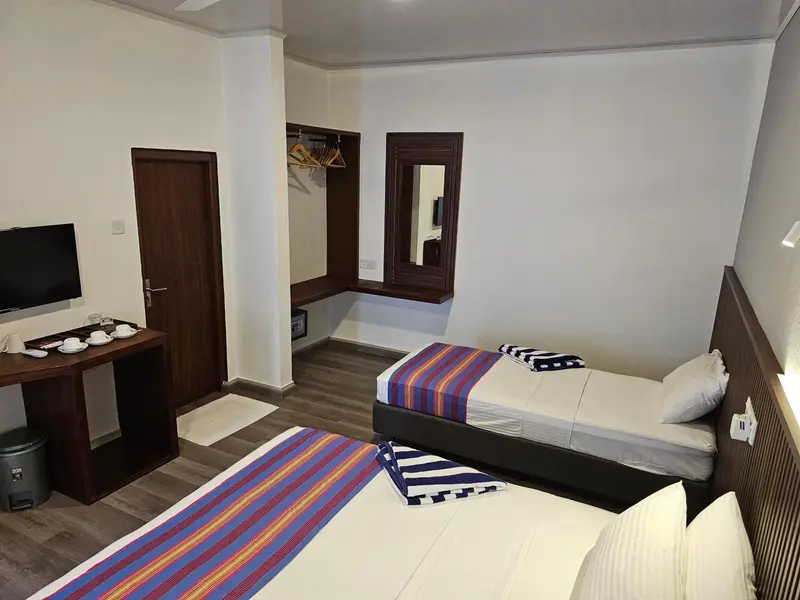 Une chambre lumineuse avec deux lits simples et un espace détente.