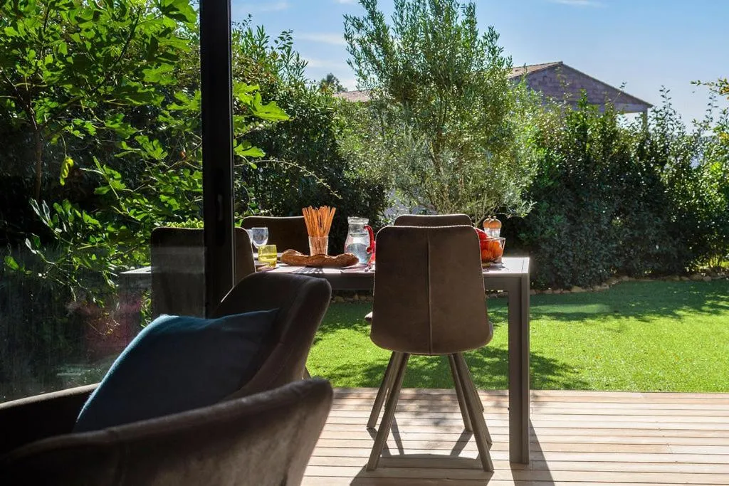 Une table à manger est mise en scène sur une terrasse en bois.