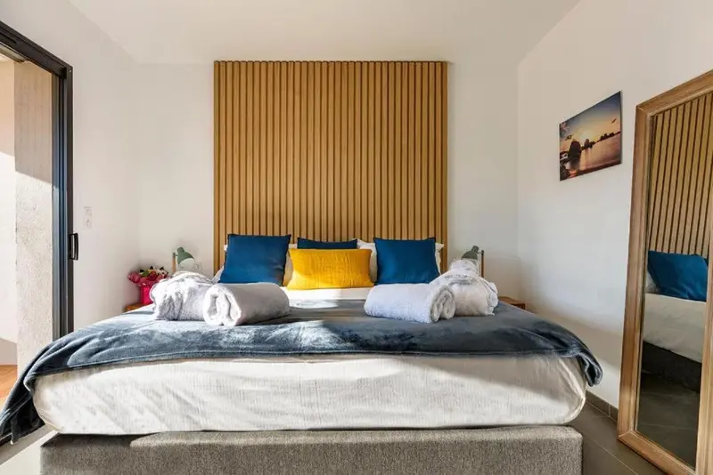 Une chambre avec un grand lit recouvert de coussins et de couvertures.