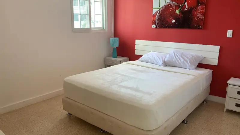 Une chambre lumineuse avec un lit double et une décoration murale.