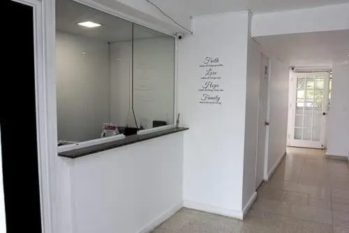 Un comptoir d'accueil blanc avec un miroir au fond.