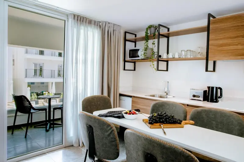 Une cuisine moderne avec un coin repas lumineux et une vue sur l'extérieur.